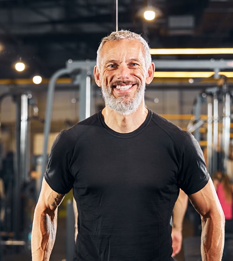 joyous-personal-trainer-standing-at-the-gym-2025-03-08-20-39-18-utc